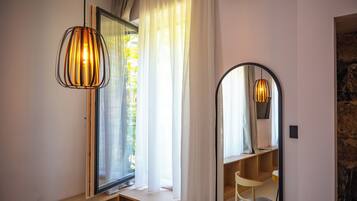 Una habitación con un banco de madera, un espejo y una lámpara colgante.