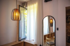 A room with a wooden bench, a mirror, and a hanging light fixture. - Hotel Risnjak (Delnice)