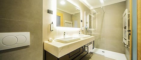 A modern bathroom with a dual sink vanity, a large mirror, and a glass shower enclosure.