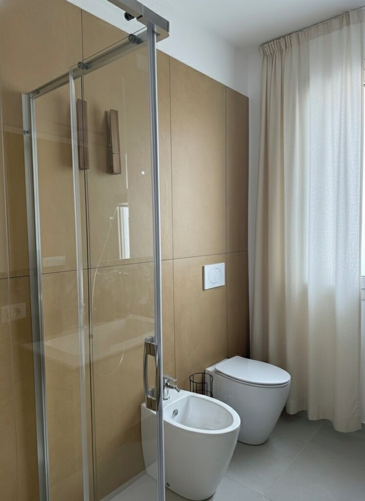 Deluxe appartement | Badkamer | Een douche, een haardroger, een bidet, handdoeken