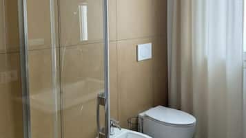Deluxe appartement | Badkamer | Een douche, een haardroger, een bidet, handdoeken