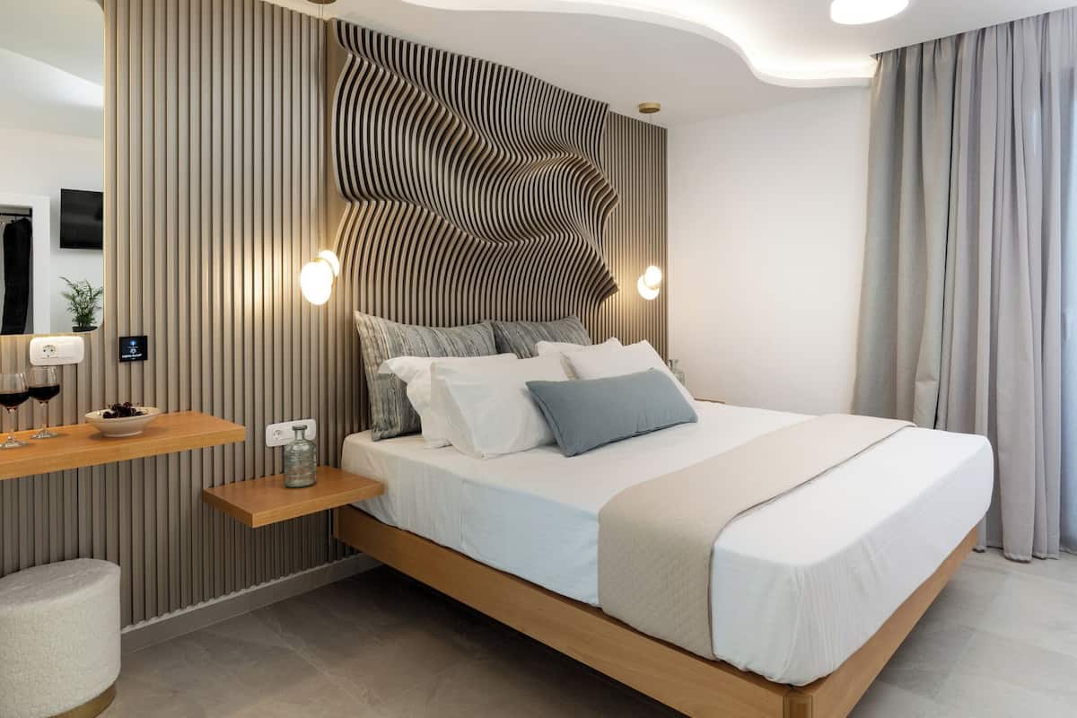 Un dormitorio moderno con una cama de madera, una mesita de noche, una lámpara de pared e instalación de sonido integrada.