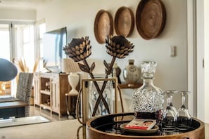 A dining area with a wooden table, a glass decanter, and wine glasses.