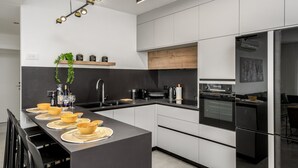 Eine moderne Küche mit einer zentralen Kochinsel, integrierten Geräten und einem minimalistischen Design.