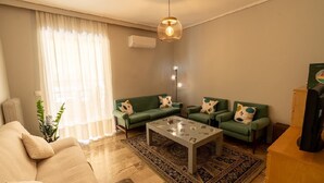 A living room with a sofa, two armchairs, a coffee table, and a rug. - Cozy Apartment in Faliro (Palaio Faliro)
