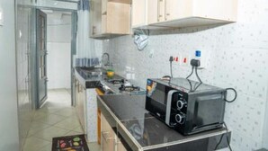 Une cuisine de taille réduite équipée d’une cuisinière à gaz, d’un grille-pain et d’un four à micro-ondes.