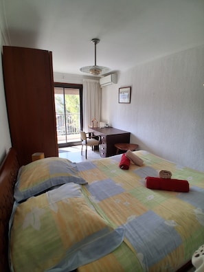 Ein Hotelzimmer mit Bett, Schreibtisch, Stuhl und Fenster.