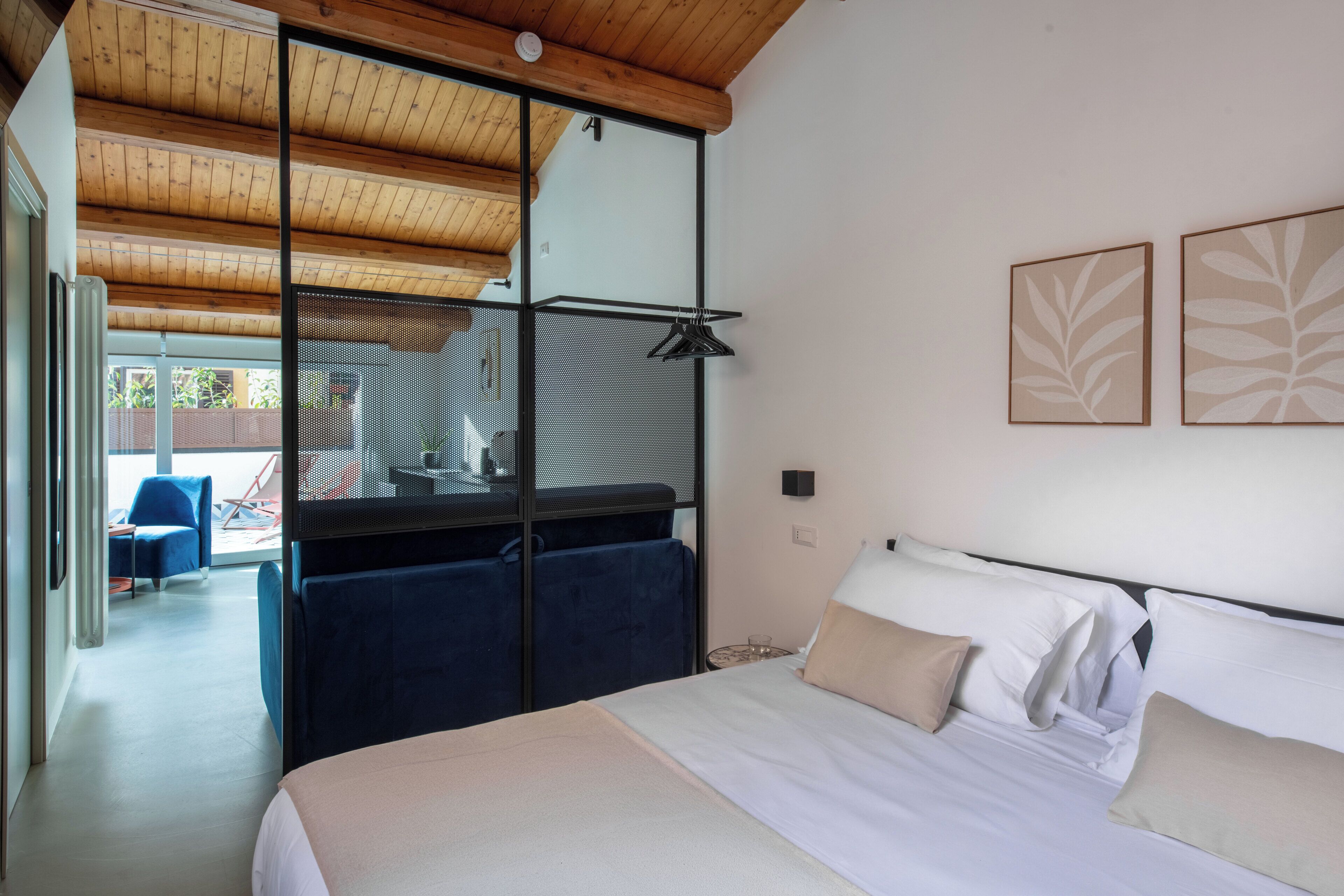 Een slaapkamer met een bed, een bureau, een stoel en uitzicht op het buiten.