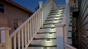 A staircase with white railings and illuminated steps. - Fabulous 4-bedroom channel home with private dock in Cherry Grove Beach. (North Myrtle Beach)