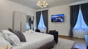 A modern hotel room with a large bed, a flat-screen TV, a desk, and a chair. - Angelo Prestige Canal View (Venice)