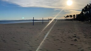 A beach with a clear sky, a sunset, and palm trees. - Casa Peroscalou Roses – Modern Villa with Panoramic Views, 3 Bedrooms, Near Costa Brava Beaches (El Mas Fumats)