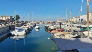 A marina with boats docked along the water, a clear sky, and buildings in the background. - Casa Peroscalou Roses – Modern Villa with Panoramic Views, 3 Bedrooms, Near Costa Brava Beaches (El Mas Fumats)