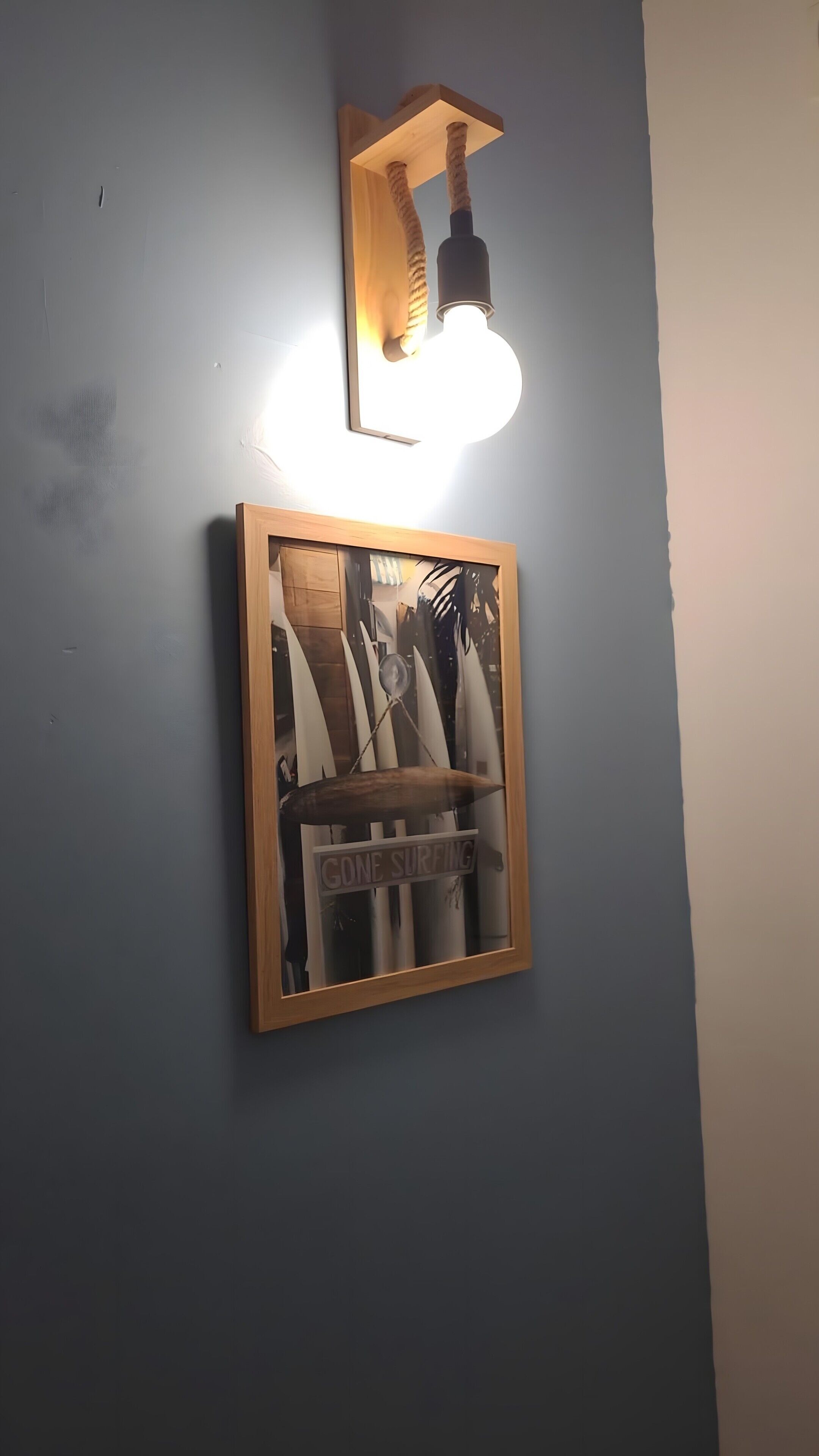 Ein gerahmtes Bild von Surfbrettern mit dem Schriftzug 'CONE SURFING' an einer Wand.