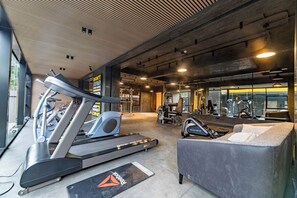 A gym with treadmills, elliptical machines, and a massage chair. - Kilimani, Wilma Tower, Studio, Steam, Sauna, Pool &Gym (Nairobi)
