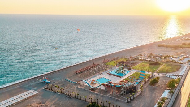 An aerial view of a coastal resort with a swimming pool, water park, and beach area. - Casa Fora Beach Resort (Manavgat)