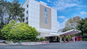 A modern hotel with a large entrance, a covered waiting area, and a parking lot. - Hotel Tamilnadu Pandiyan Madurai (Madurai)