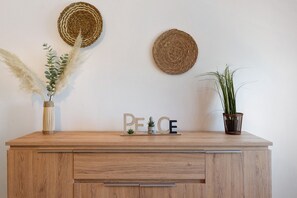 A wooden cabinet with a plant and decorative items on top.
