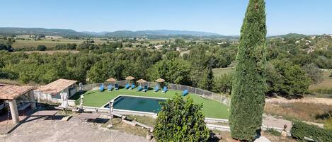 Zona de piscina amb gandules i vista al camp circumdant.