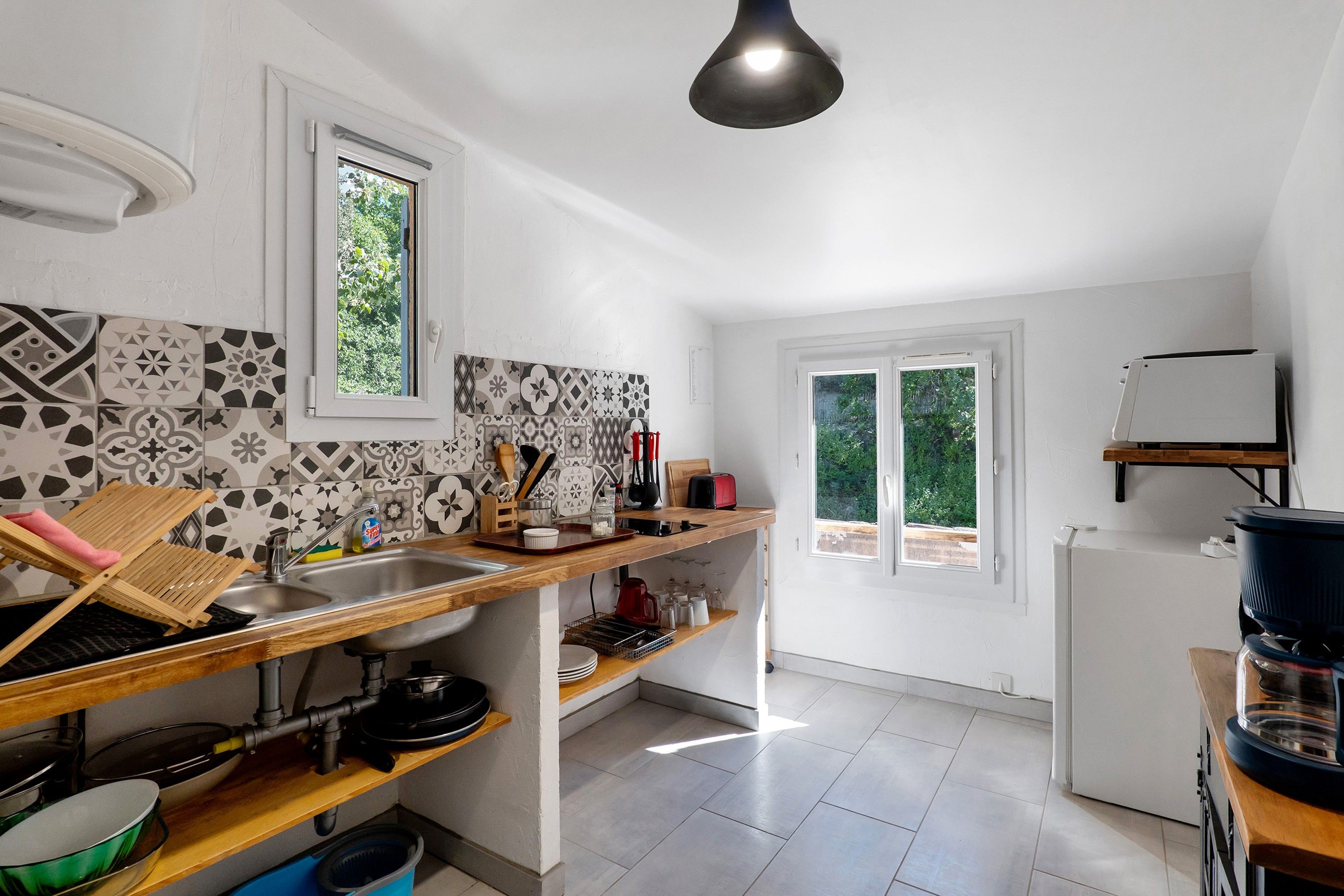 Une cuisine de taille réduite, équipée d’un évier, d’un plan de travail en bois et d’une fenêtre.