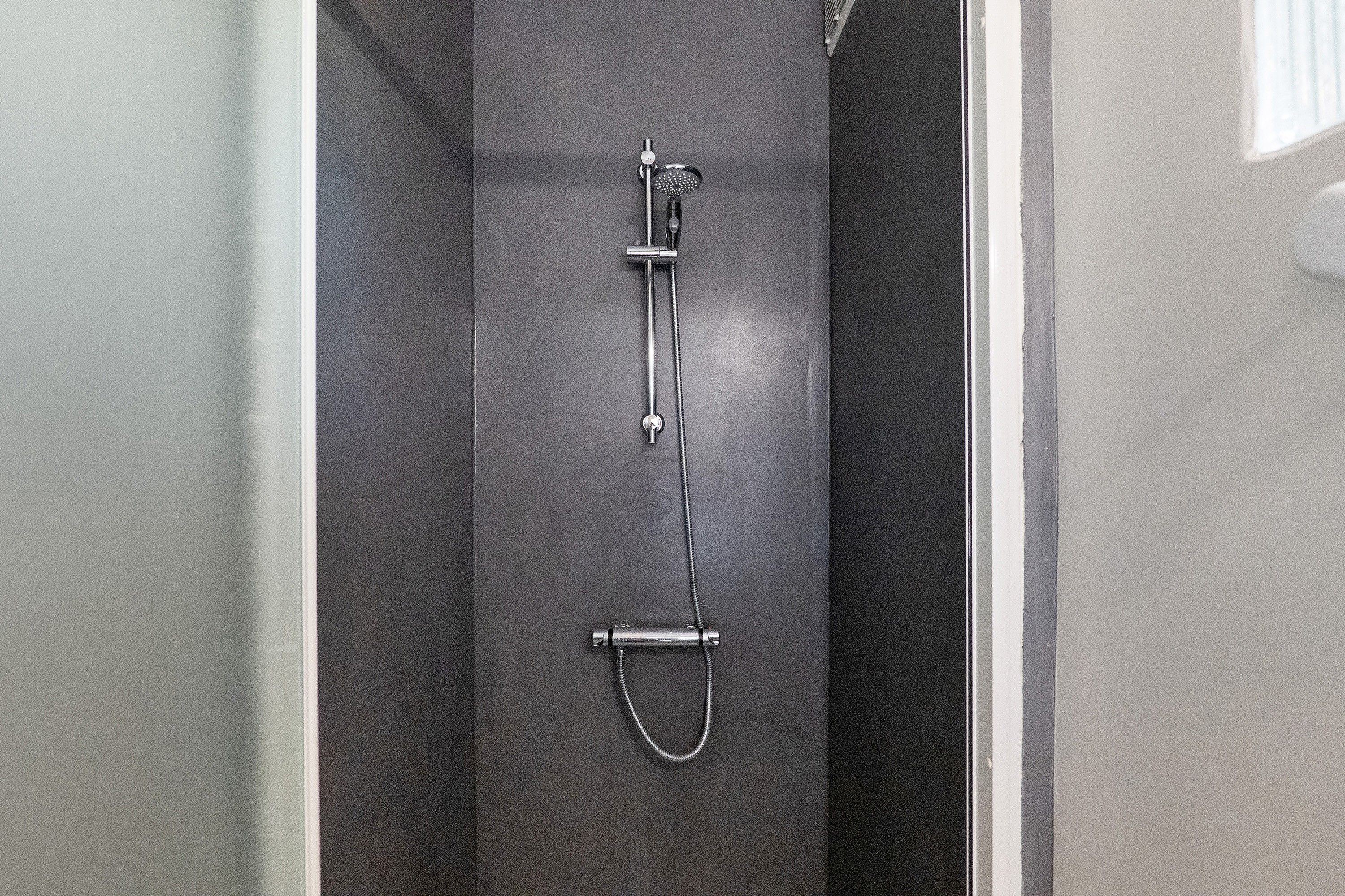 Una doccia con soffione estraibile e spazzola da bagno manuale.