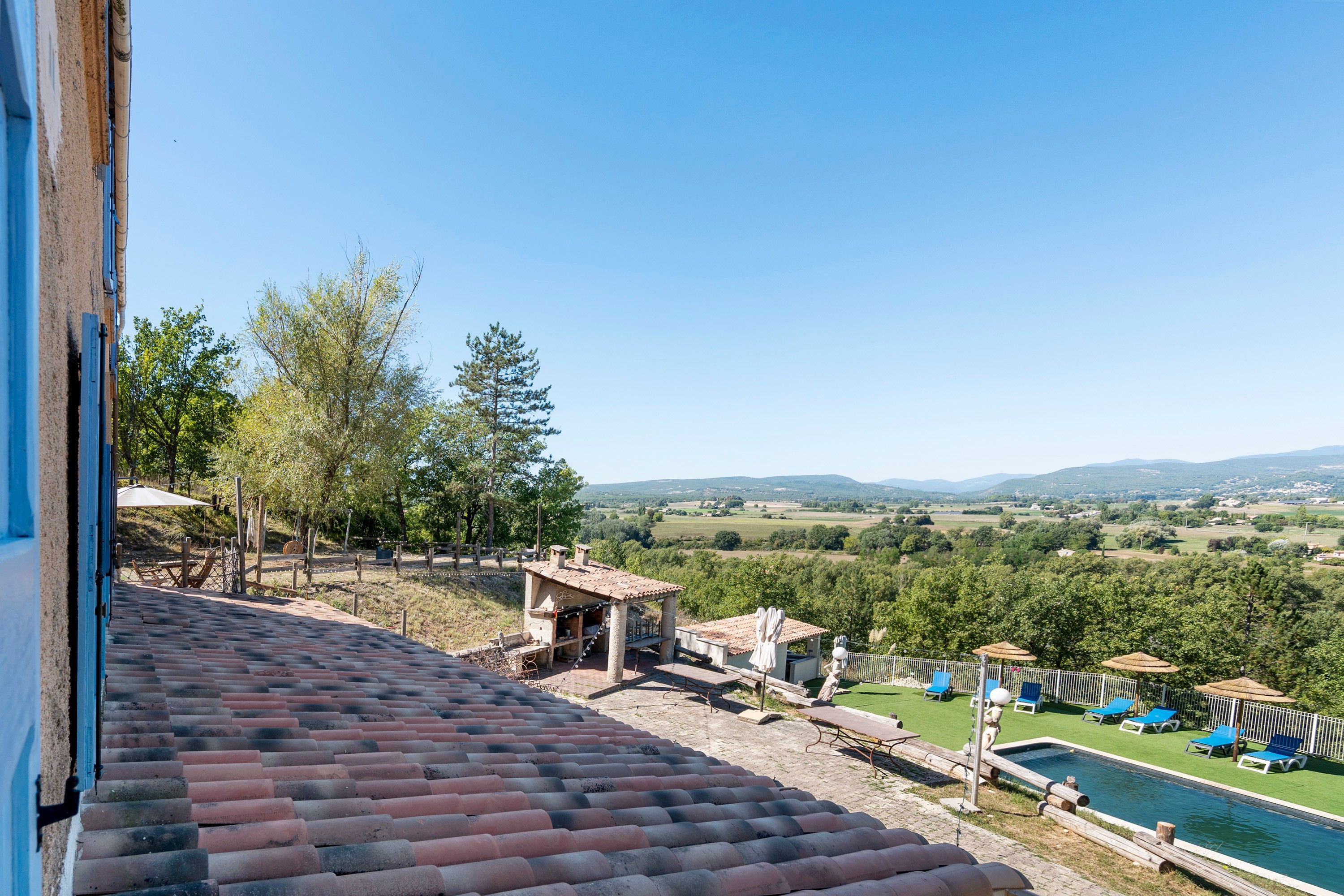 Una terraza con vistas a una piscina y un paisaje campestre.