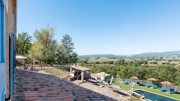Una terraza con vistas a una piscina y un paisaje campestre.