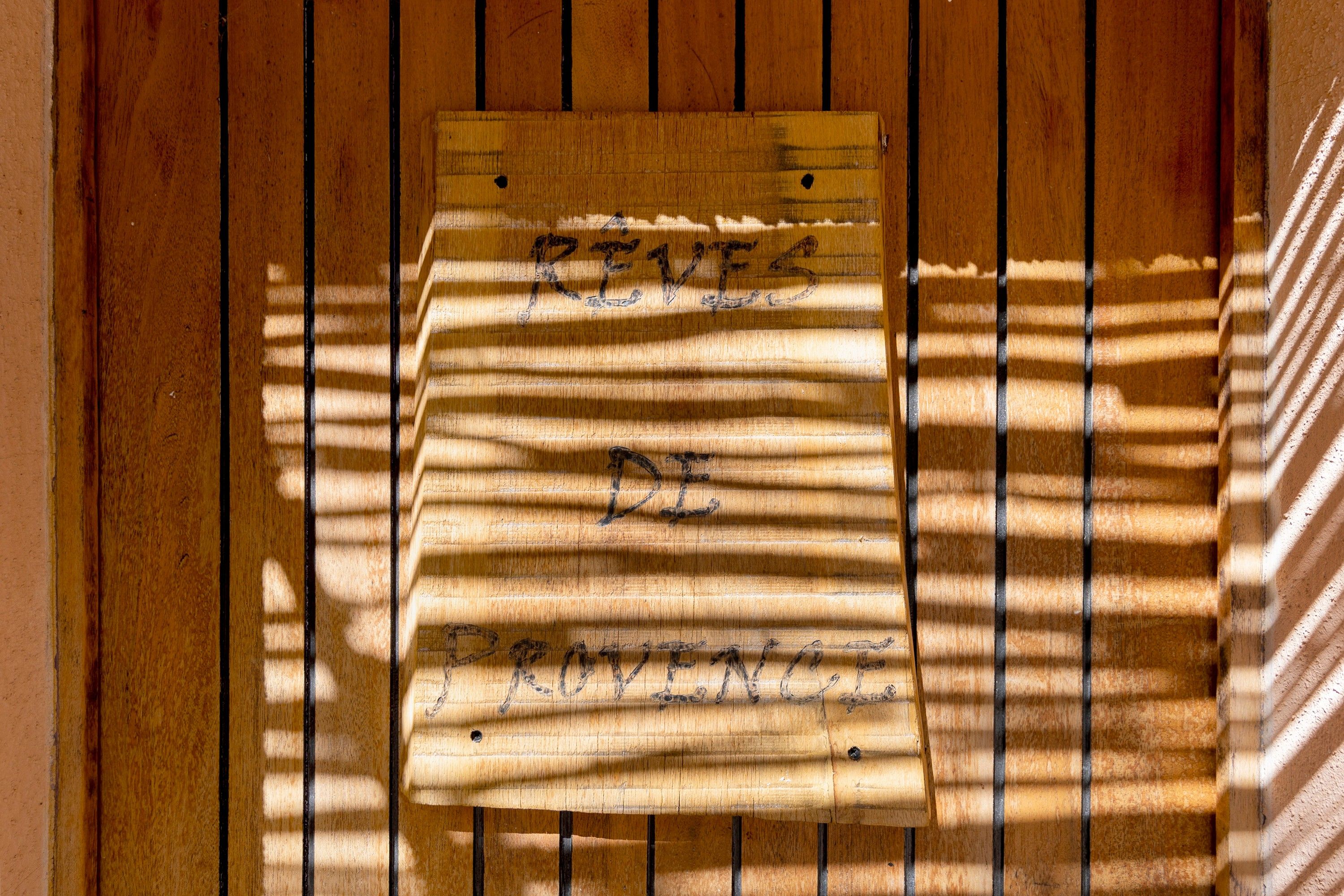 A wooden surface with a piece of paper taped to it, containing handwritten text.