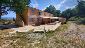 Un bâtiment à deux étages doté d’un patio, d’un espace extérieur aménagé pour s’asseoir et offrant une vue sur la campagne.
