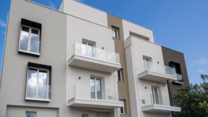 A modern multi-story building with balconies, large windows, and a flat roof. - Brezza Apartments (Santa Flavia)