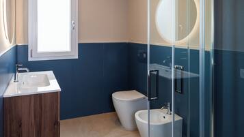 Un bagno con lavandino, WC e cabina doccia in vetro.