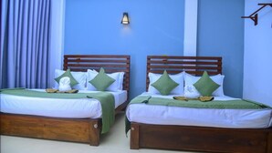 A room with two wooden beds, each with a green pillow and a white blanket. - Belvita Resort Ella (Ella)