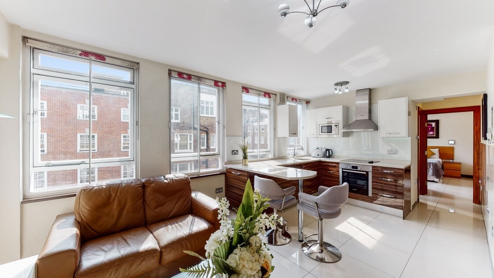 A modern apartment with a living room, kitchen, and dining area.