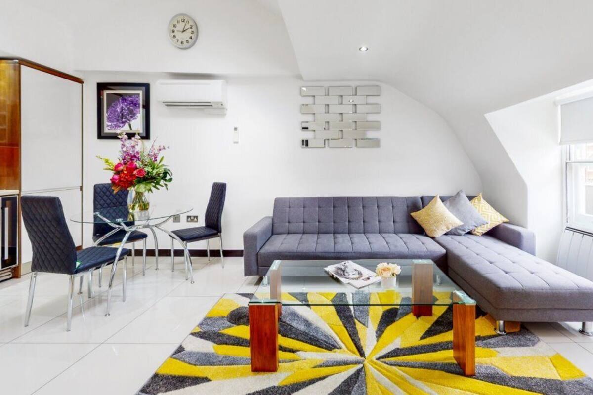 A modern living room with a sofa, chairs, a coffee table, and a patterned rug.