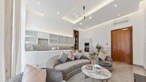 A modern living room with a sofa, a coffee table, and a kitchen in the background. - Gloucester Place (London)