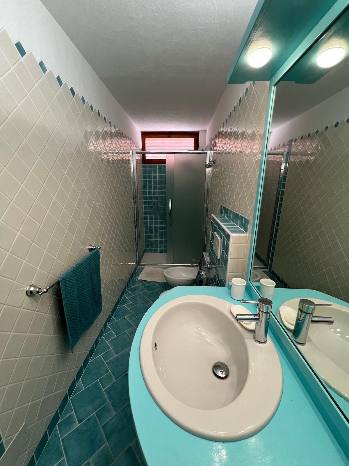 Baño con lavabo, espejo y cabina de ducha.