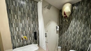 Ein Badezimmer mit Badewanne, Toilette, Dusche und Handtuchhalter.