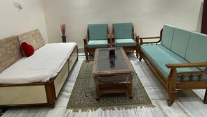 Ein Zimmer mit einer Couch, zwei Sesseln, einem Couchtisch und einem Teppich.