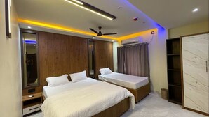 A modern bedroom with two beds, a ceiling fan, and a built-in wardrobe.