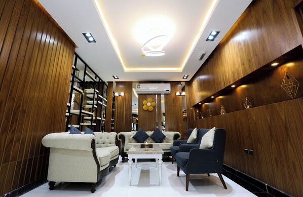 A modern interior with a sofa, armchairs, a coffee table, and wooden paneling.