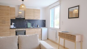 Une cuisine moderne avec des meubles en bois, un pare-feu en marbre et un four encastré.