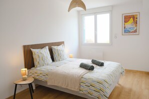 A bedroom with a bed, bedside lamps, a window, and a poster on the wall. - Les embruns - 4 people (Criel-sur-Mer)