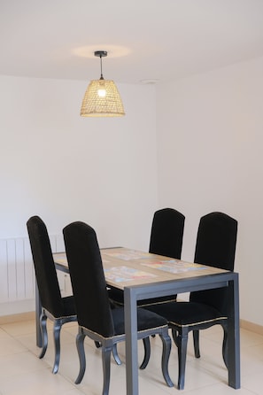 A dining table with four chairs, a hanging light fixture, and a radiator. - Les embruns - 4 people (Criel-sur-Mer)
