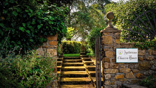 A stone staircase leading to a gate with a sign reading 'Agriculture Chiarello Bosco.' - Ghiaccio Bosco Capalbio (Capalbio)