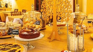 A buffet with various food items and a decorative tree-like structure. - Ghiaccio Bosco Capalbio (Capalbio)
