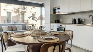 A modern dining area with a round table set for four, surrounded by wicker chairs. - Superb terrace apartment in Monaco-Beausoleil (Beausoleil)