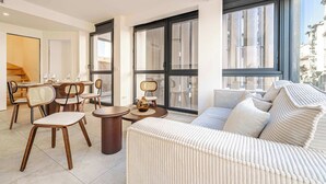 A modern living room with a sofa, chairs, a coffee table, and large windows. - Superb terrace apartment in Monaco-Beausoleil (Beausoleil)