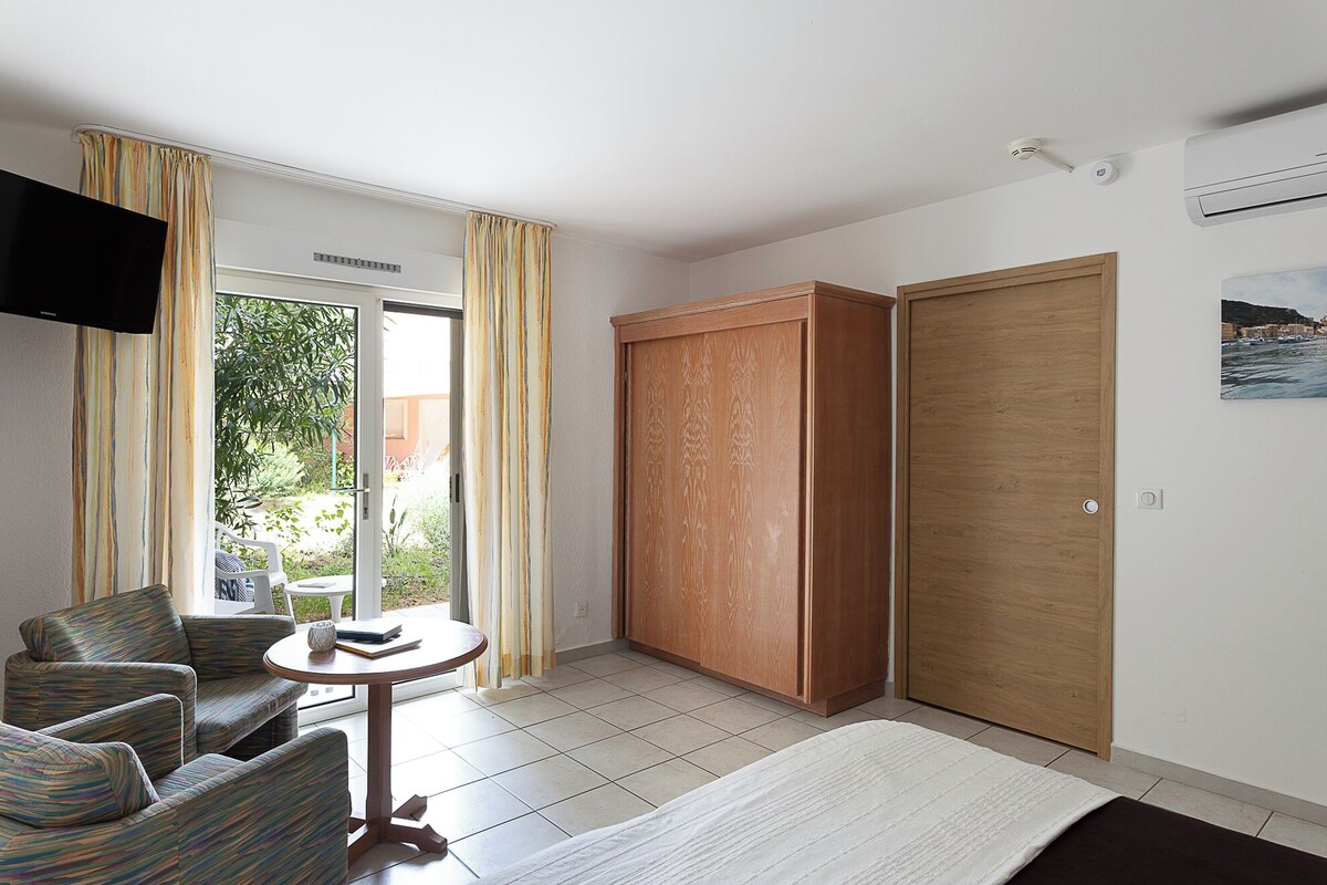 Una habitación con sofá, una mesita, armario y televisor.