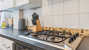 A kitchen with a gas stove, a kettle, and a knife block. - 2 Bedroom Birmingham J Quarter With Parking & Wifi (Birmingham)