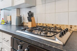 Eine Küche mit einem Gasherd, einem Wasserkocher und einem Messerblock.