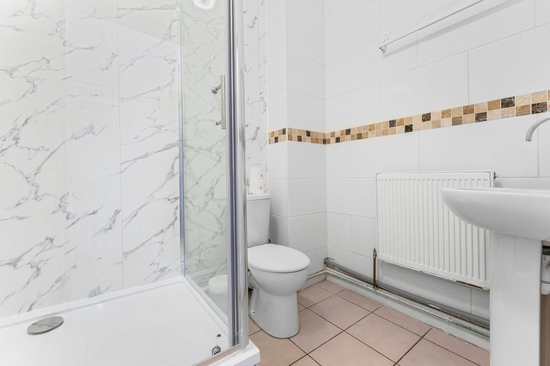 A bathroom with a shower, toilet, and sink.